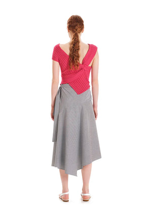 Woman wearing a pink top and gray skirt on a white background