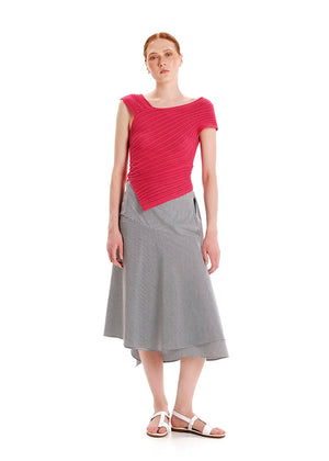 Woman wearing a pink top and gray skirt on a white background