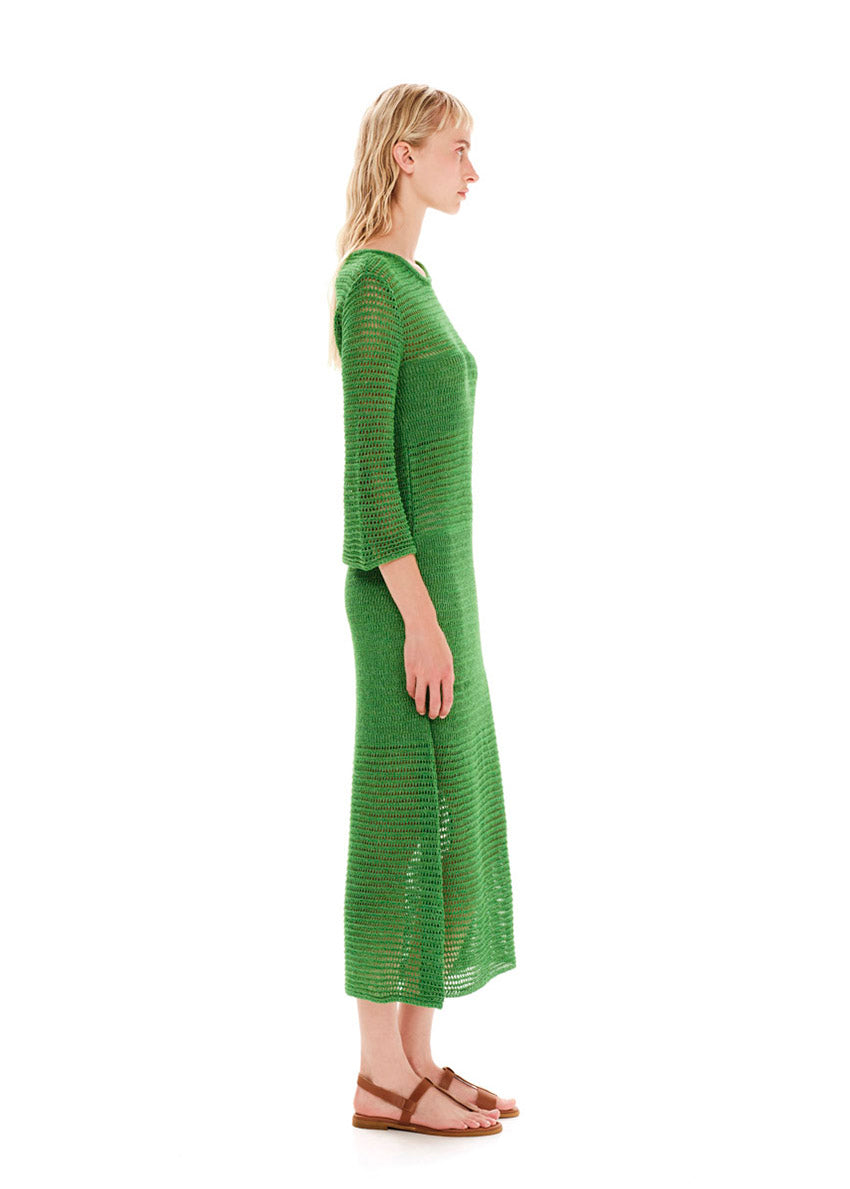 Maxi green dress with a loose knitting in a straight fit.It has long bell sleeves and a slit on the side.Creates an airy silhouette for your carefree summer strolls.