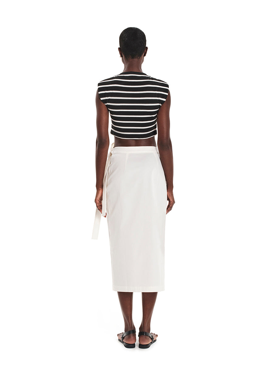 A model wearing a fitted crop top with a striped pattern, paired with a white skirt.