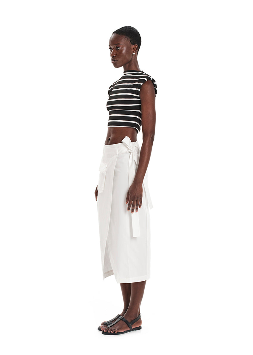 A model wearing a fitted crop top with a striped pattern, paired with a white skirt.