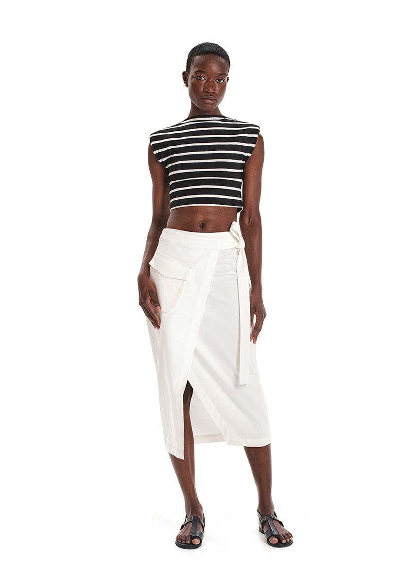 A model wearing a fitted crop top with a striped pattern, paired with a white skirt.
