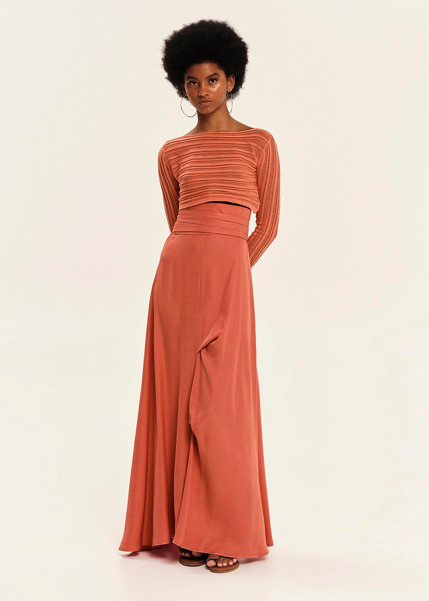 Woman wearing a rust-colored two-piece outfit on a white background