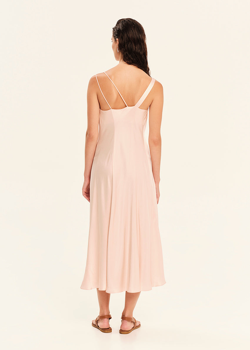 Woman wearing a light pink slip dress on a white background