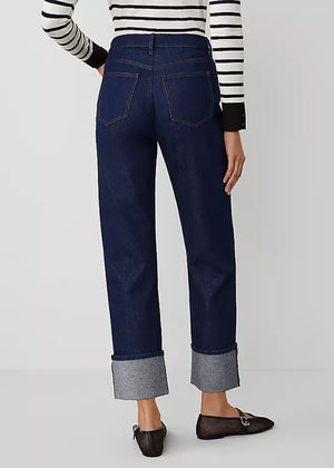 Person wearing dark blue jeans with sparkly  cuffs on a white background