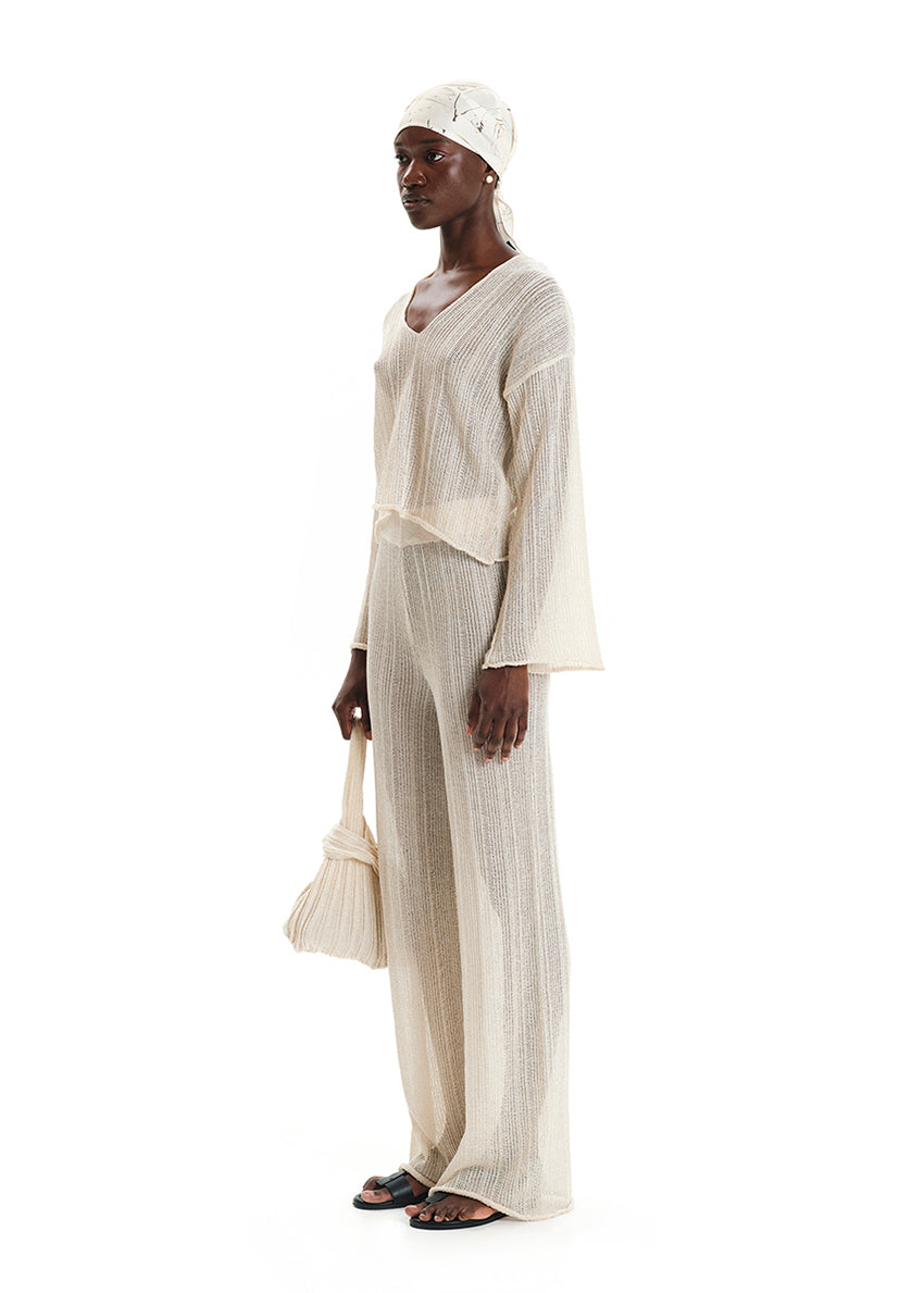 A shimmering cornsilk sweater with a V-neck and long sleeves, displayed against a white background.