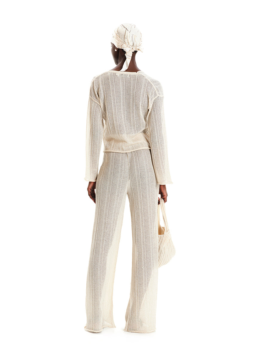 A stunning blend of elegance and modernity. Available in classic black and chic ecru, this top features a shimmering finish that captures the light beautifully. Crafted with a luxurious, sparkling fabric, this sweater offers a flattering fit and a touch of glamour