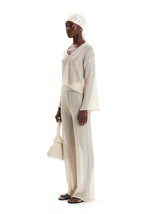 A shimmering cornsilk sweater with a V-neck and long sleeves, displayed against a white background.