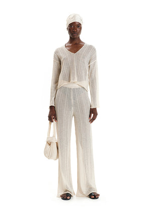 A shimmering cornsilk sweater with a V-neck and long sleeves, displayed against a white background.