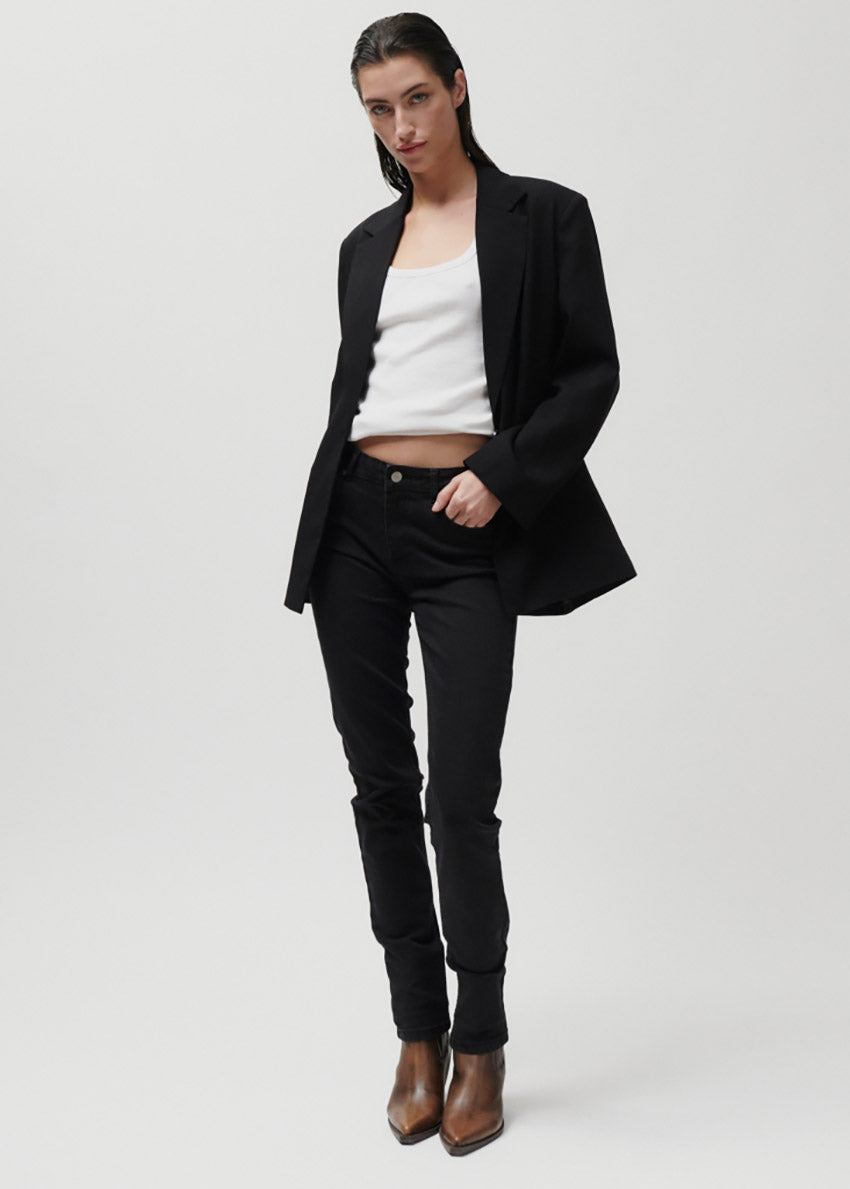 Person wearing black pants and brown boots on a white background