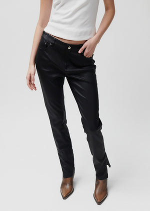 Person wearing black pants and brown boots on a white background