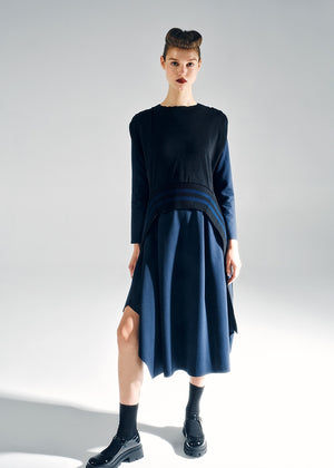 Woman wearing a black top and navy blue skirt on a white background