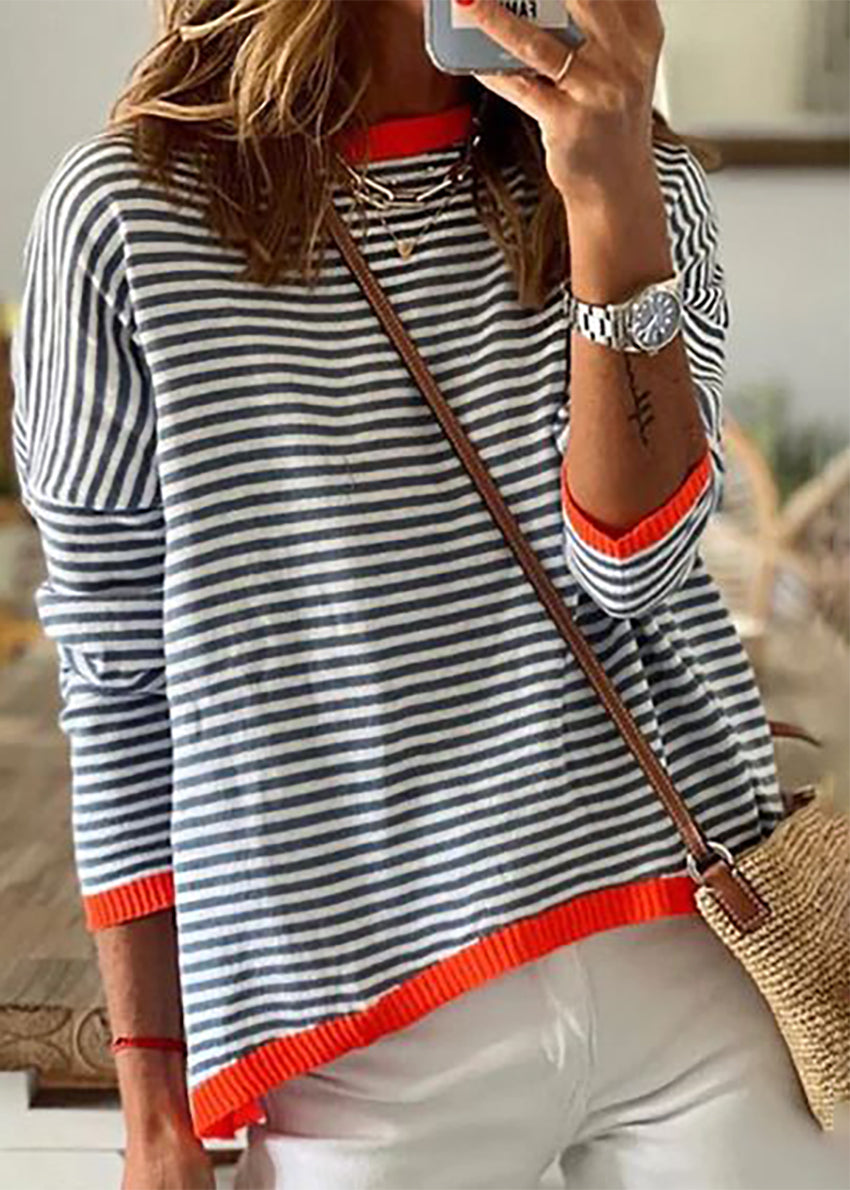 A person wearing a striped crop top with a wide boat neckline and cropped cut, paired with white pants, accessorized with a bag and a watch.