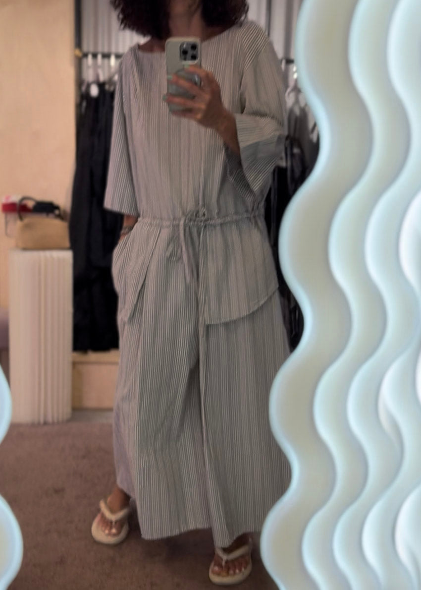 Person wearing a striped dress in front of a mirror.