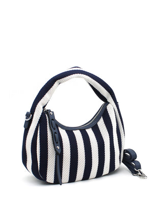 A handbag with a bold black and white striped design, featuring a crescent shape and a detachable strap.