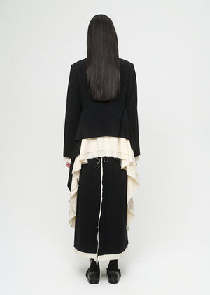 Person wearing a black outfit with a white layered coat on a white background