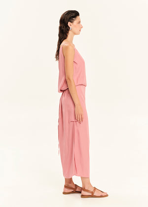 Woman wearing a straight-cut maxi dress with discret key hole at the bust and delicate pleats along the side seams, white side ties allow to create a new silhouette that drapes around the waist.