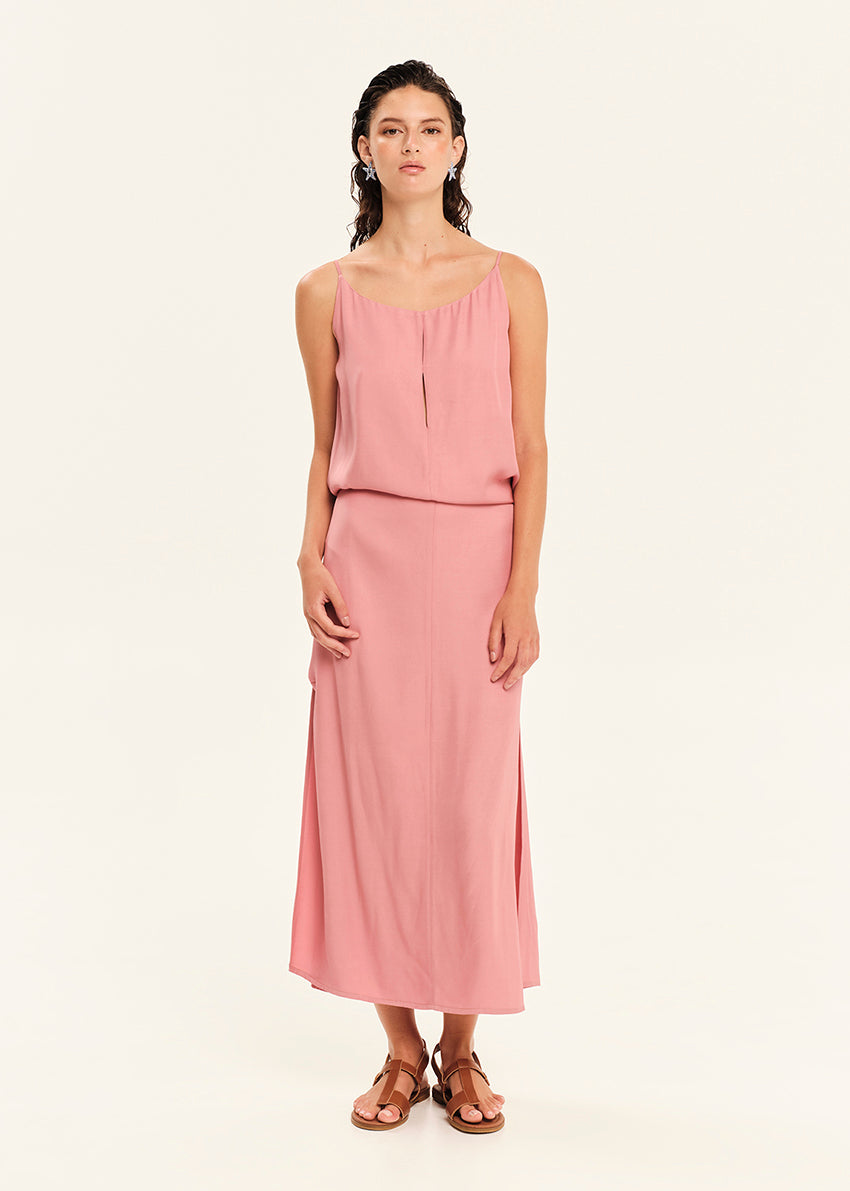 Woman wearing a straight-cut maxi dress with discret key hole at the bust and delicate pleats along the side seams, white side ties allow to create a new silhouette that drapes around the waist.