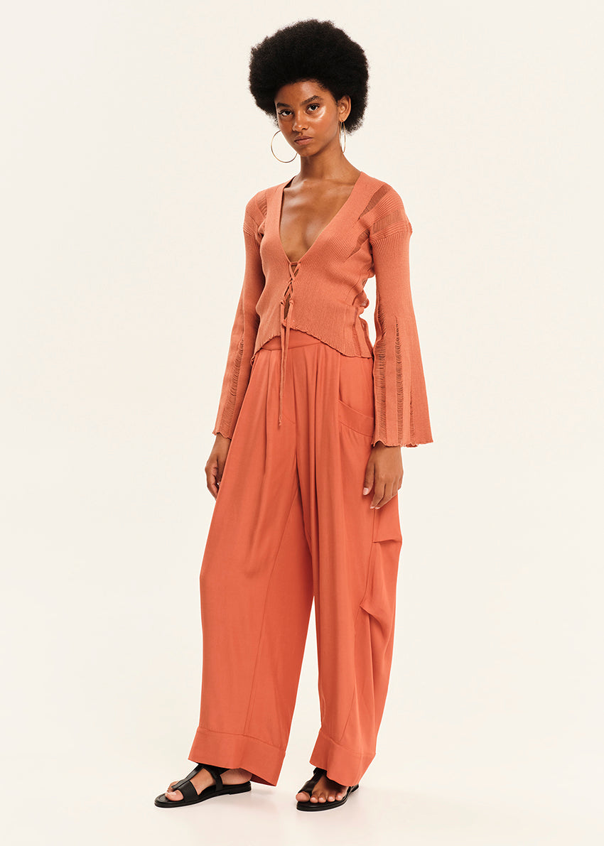 Woman wearing a peach-colored outfit on a white background