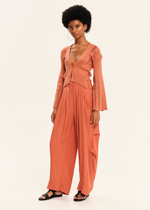 Woman wearing a peach-colored outfit on a white background