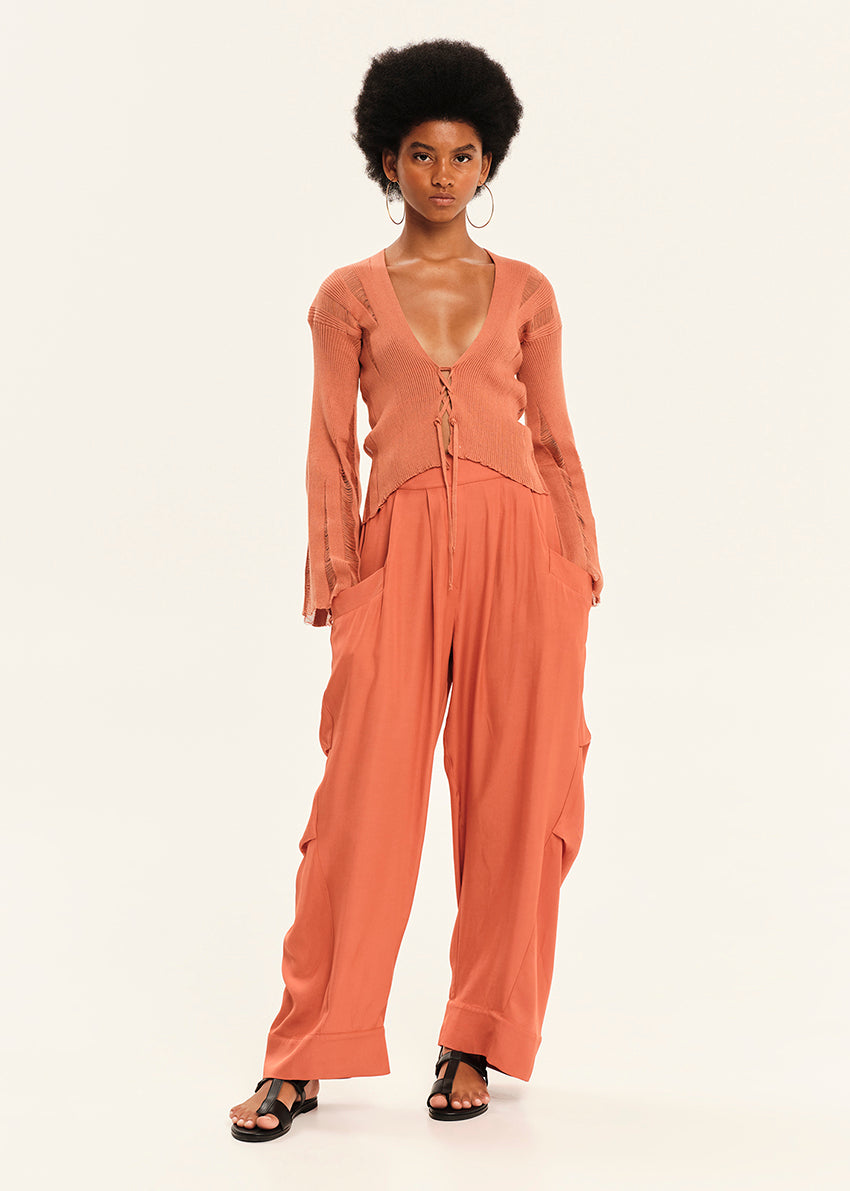Woman wearing a rust-colored outfit on a white background