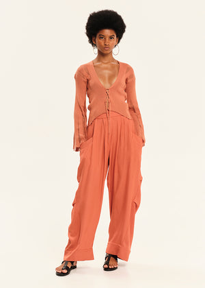 Woman wearing a rust-colored outfit on a white background