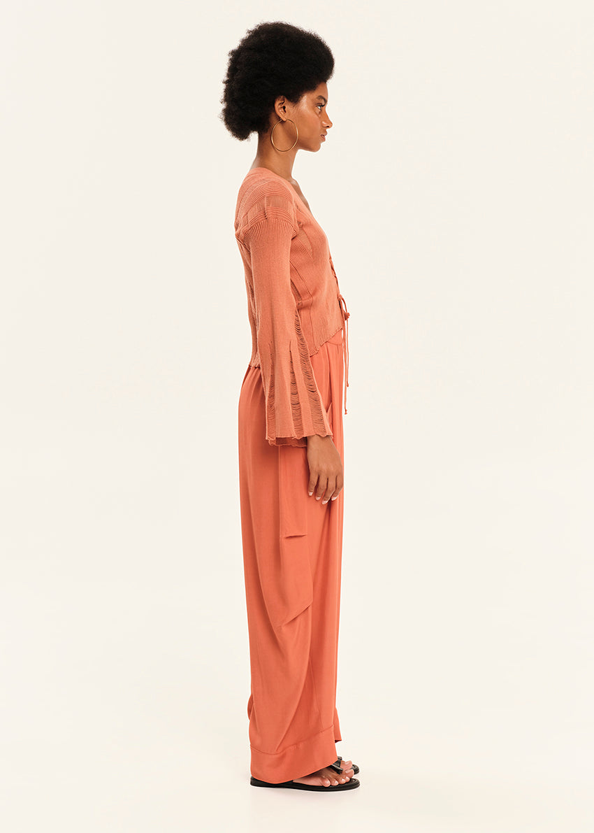 Woman wearing a peach outfit on a white background