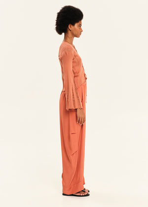 Woman wearing a peach outfit on a white background