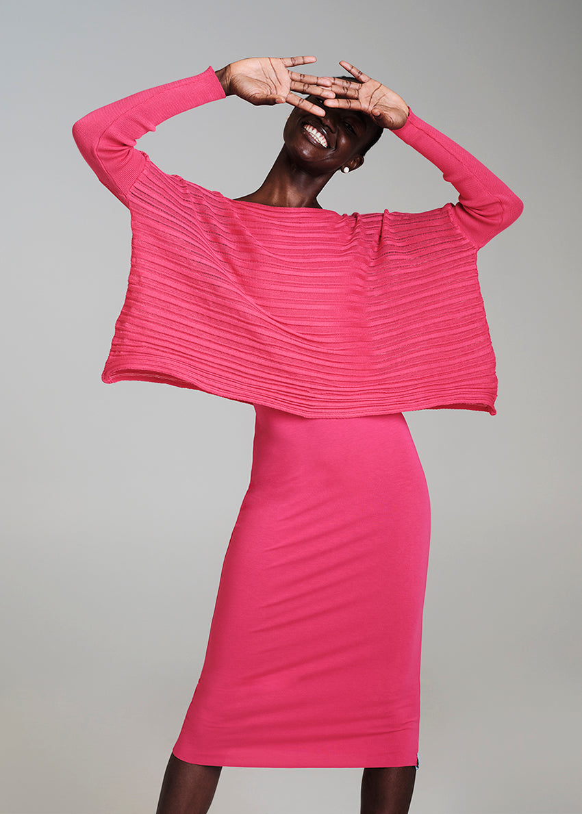 A model wearing a pink sleeveless midi dress with a round neckline and twisted shoulders.