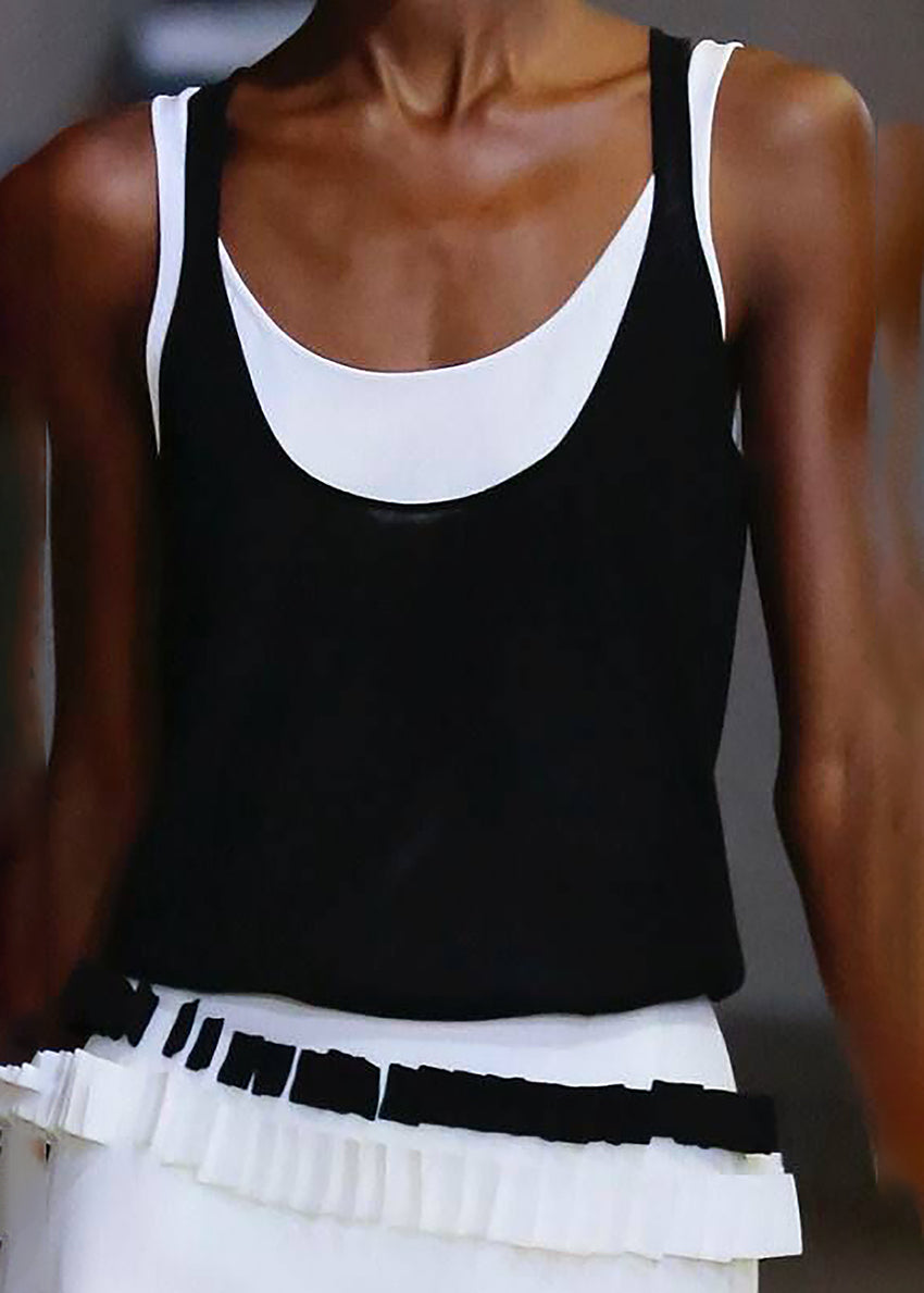 A close-up of a sleeveless black and white tank top with a round neckline.
