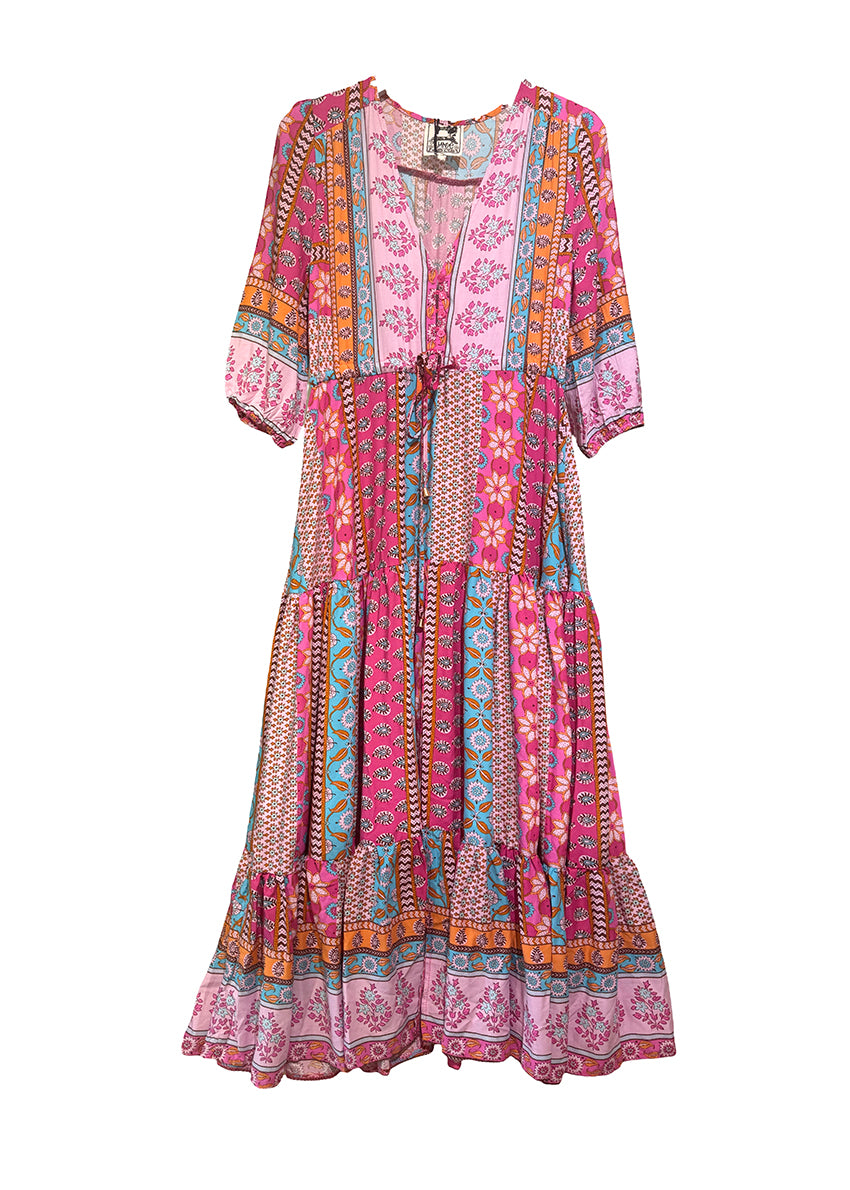 A woman standing by a pool wearing a multicolored floral maxi dress with 3/4 sleeves and V-neckline.