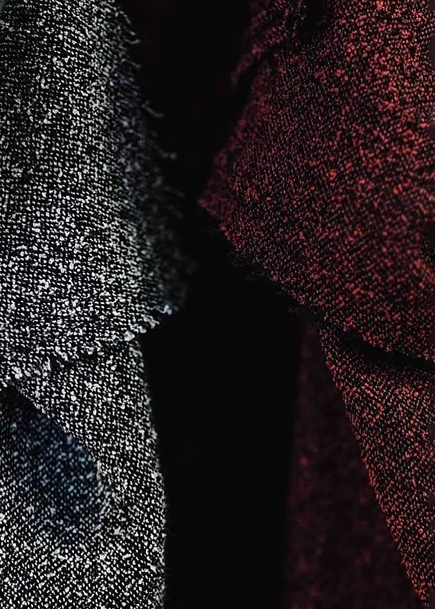 A unisex top with a crepe texture, featuring a relaxed fit with slightly dropped shoulders and diagonal seams along the upper sleeves.