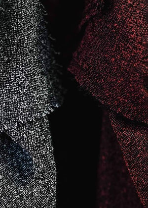 A unisex top with a crepe texture, featuring a relaxed fit with slightly dropped shoulders and diagonal seams along the upper sleeves.