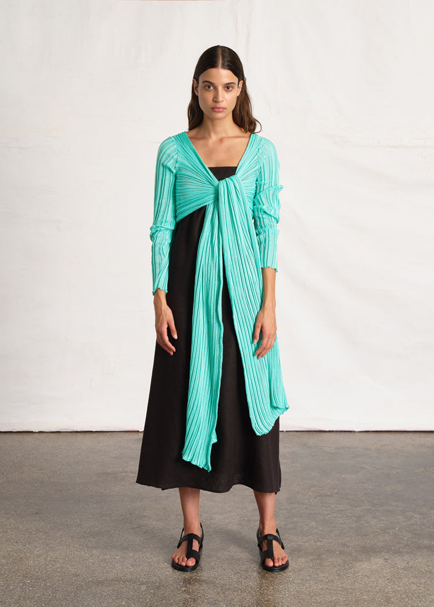 Perforated versatile knit cardigan with asymmetrical panels at the front. Made from 100% Greek cotton. The thick horizontal archetypal knitting allows for a loose flow and a beautiful fit. A very special piece, drawing inspiration from pleats