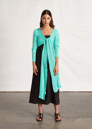 Perforated versatile knit cardigan with asymmetrical panels at the front. Made from 100% Greek cotton. The thick horizontal archetypal knitting allows for a loose flow and a beautiful fit. A very special piece, drawing inspiration from pleats