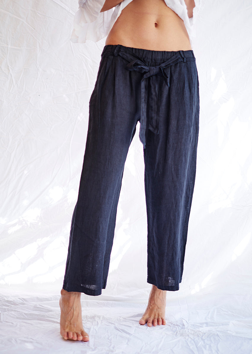 A pair of midnight blue linen pants with an adjustable tie-waist design.