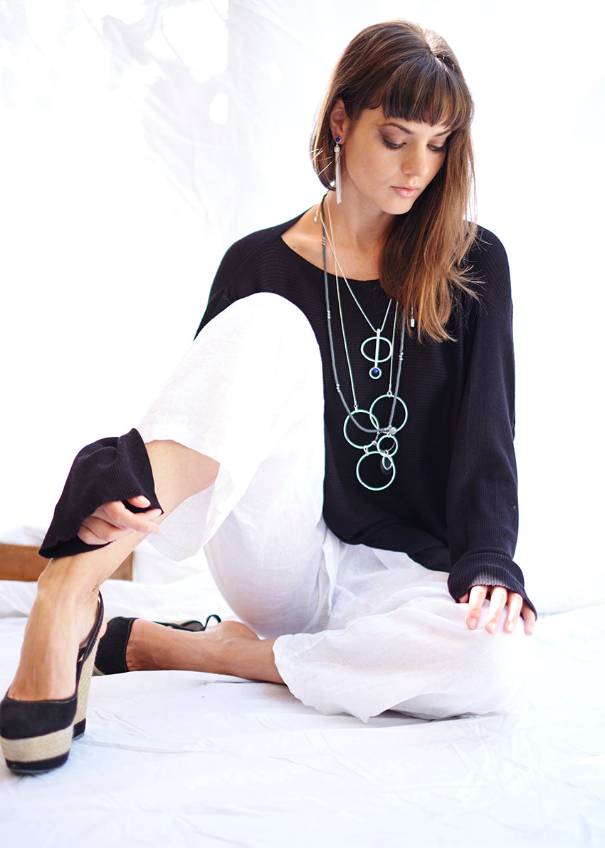 A pair of white linen pants with an adjustable tie-waist design.