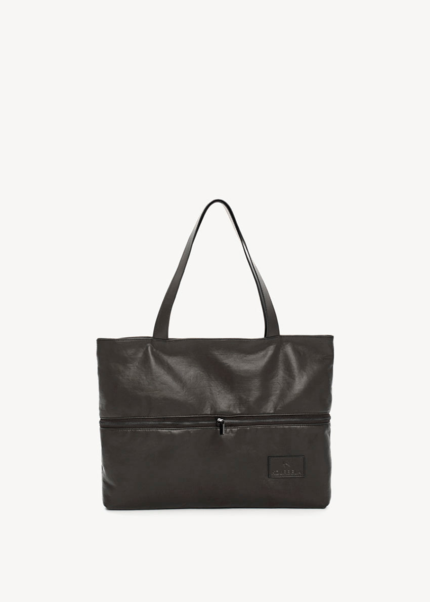 Black tote bag made of artificial leather with shoulder handles and a metallic zipper closure at the top. It features an exterior zipper for size adjustment and an inner pocket with a zipper.