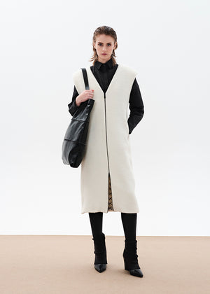 Black tote bag made of artificial leather with shoulder handles and a metallic zipper closure at the top. It features an exterior zipper for size adjustment and an inner pocket with a zipper.