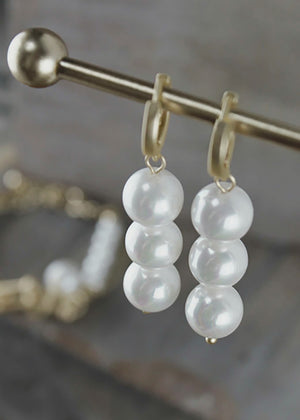 Discover the Audrey Double Pearl Earrings, a blend of 14-carat gold and uniform glass pearls for timeless sophistication. With a matte finish, these earrings add subtle elegance to any outfit, from casual to formal.