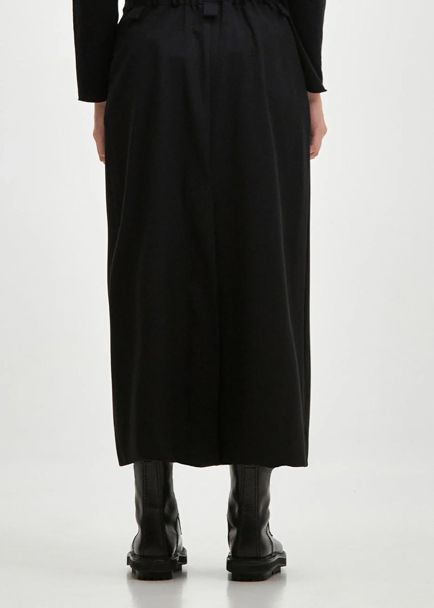 Long straight line skirt with side pockets and a slit at the back, made of blended cool wool-type viscose fabric. TUBO features a fixed waistband with elastic at the back, belt loops and closes with two front buttons and a zipper.