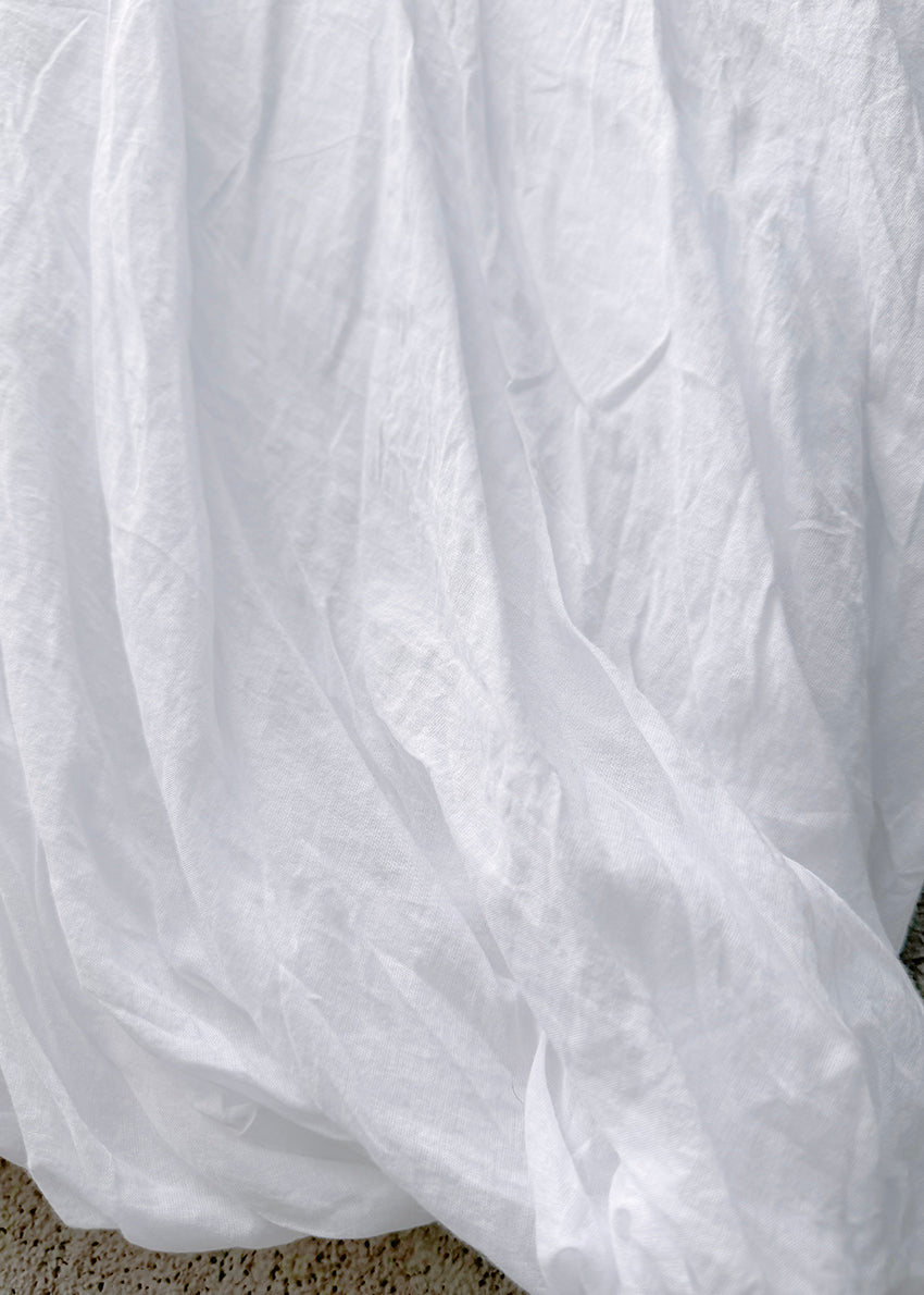 Close-up of a white fabric with visible texture on a neutral background