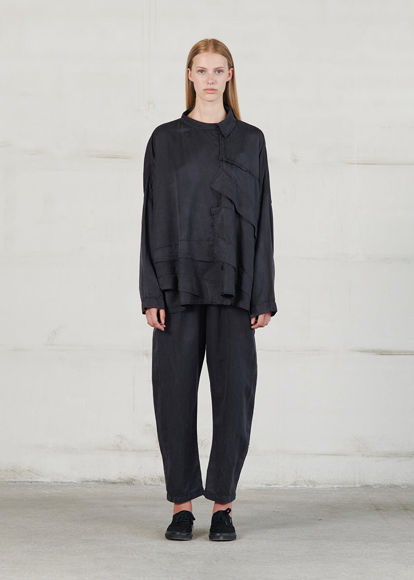 Person wearing a black outfit against a plain background