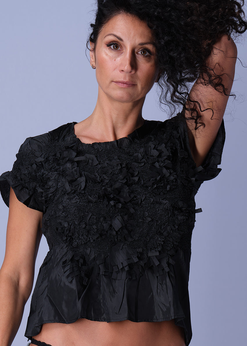 Beige top with floral lace details on a white background