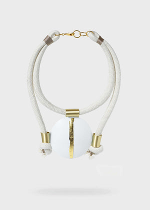 Necklace with white beads and gold accents on a light gray background