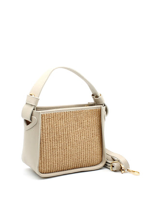 A beige handbag with a natural woven panel and leather accents, featuring an adjustable strap and sturdy handle.