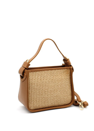 A brown handbag with a natural woven panel and leather accents, featuring an adjustable strap and sturdy handle.