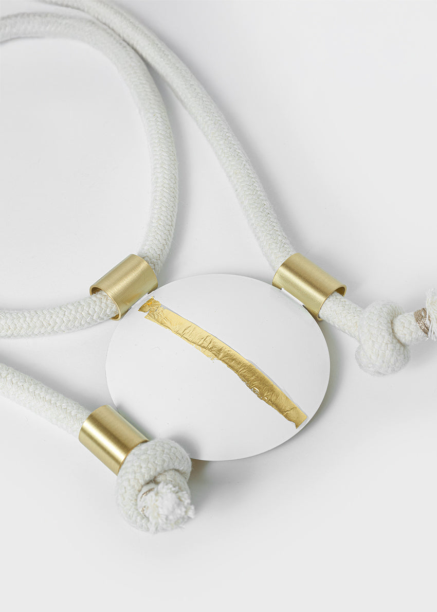 White cord with gold accents on a light gray background