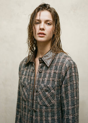 Cropped plaid jacket. The standout feature is its removable leather collar—securely attached with buttons. The jacket’s textured fabric is woven with a subtle, light-reflecting fiber. Metallic hoops, adding a vintage-inspired twist. Double front pockets and covered buttons