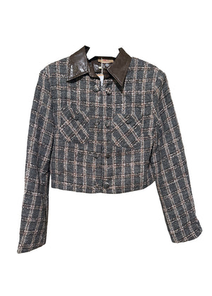 Cropped plaid jacket. The standout feature is its removable leather collar—securely attached with buttons. The jacket’s textured fabric is woven with a subtle, light-reflecting fiber. Metallic hoops, adding a vintage-inspired twist. Double front pockets and covered buttons